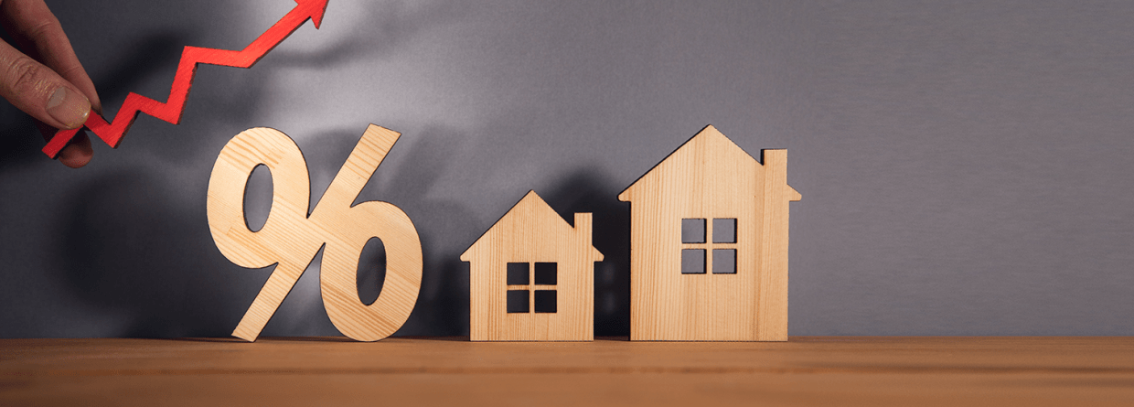 Stijgende hypotheekrente met 2 afbeeldingen van houten huizen