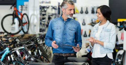 Verkoper kijkt met klant naar fietsen